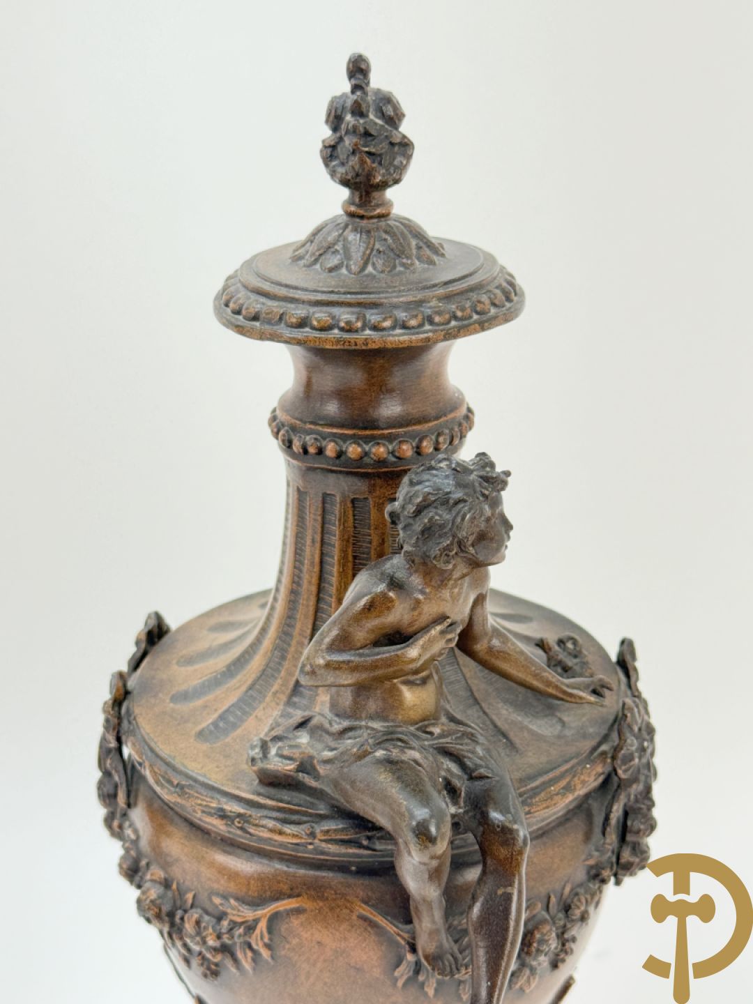 Driedelige schouwgarnituur met centrale pendule met liggende dame en cupido, geflankeerd door paar cassolettes met elegante dame