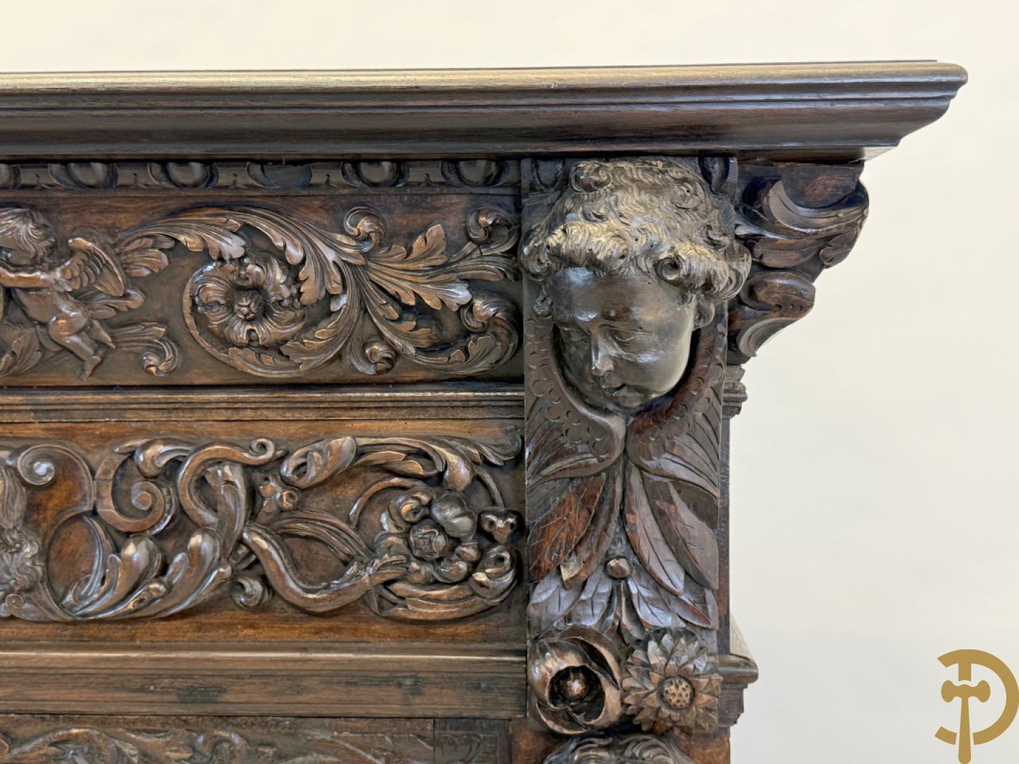 Tweedeursvitrine met Neo Renaissance sculptuur, bovenaan mlet cupidohoofden, bloemen en accanthusranken