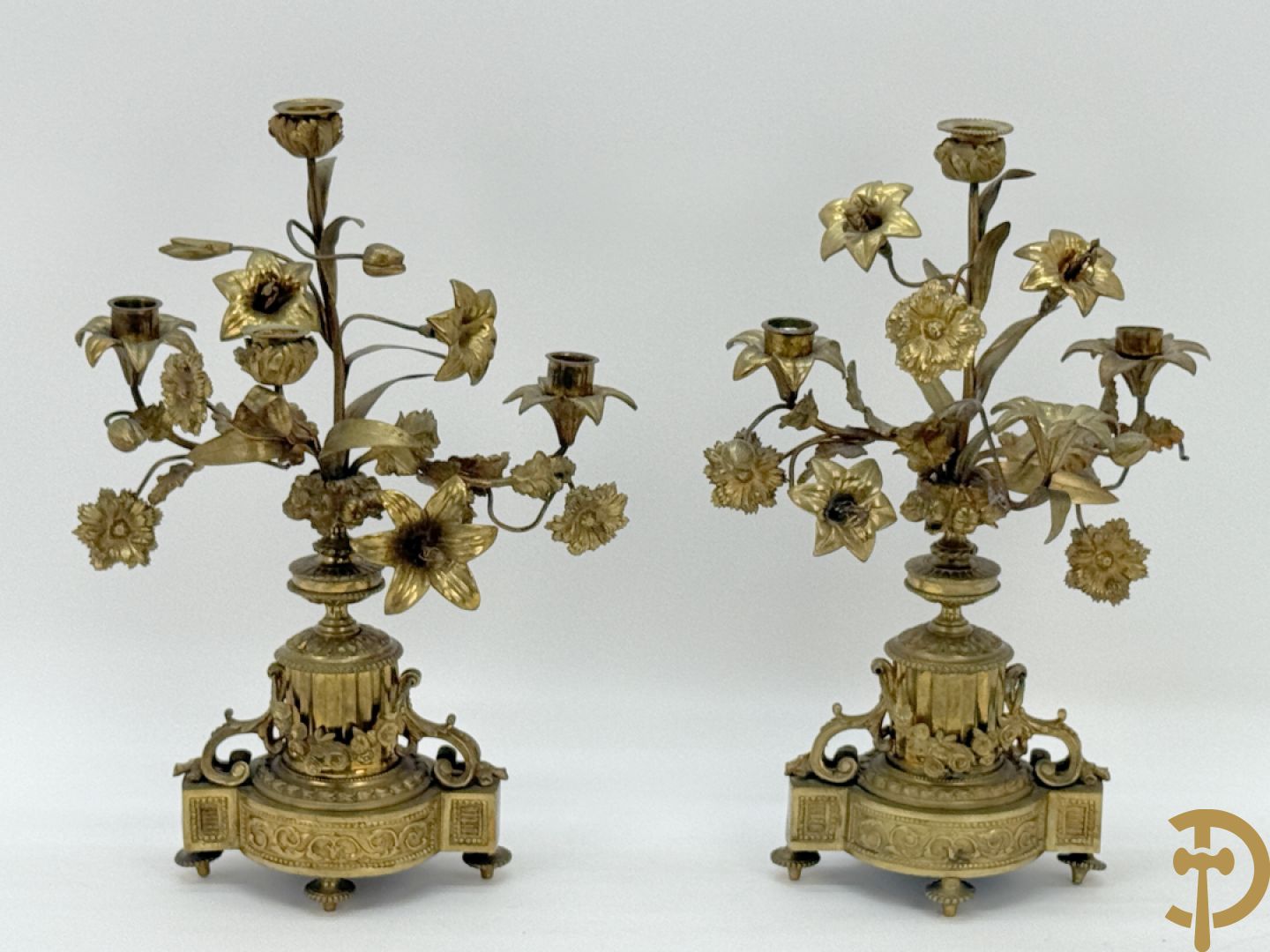 Paar bronzen kandelaars met guirlande en bloemenmotieven