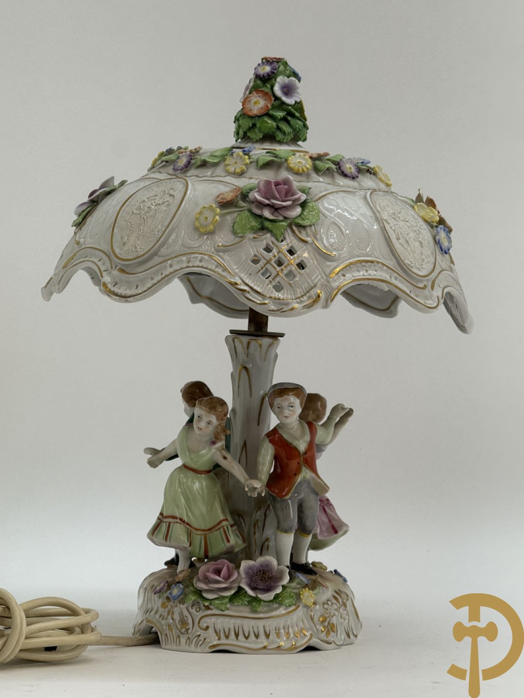 Porseleinen lampadaire met dansende figuren, bovenaan met porseleinen kap bezet met bloemmetjes