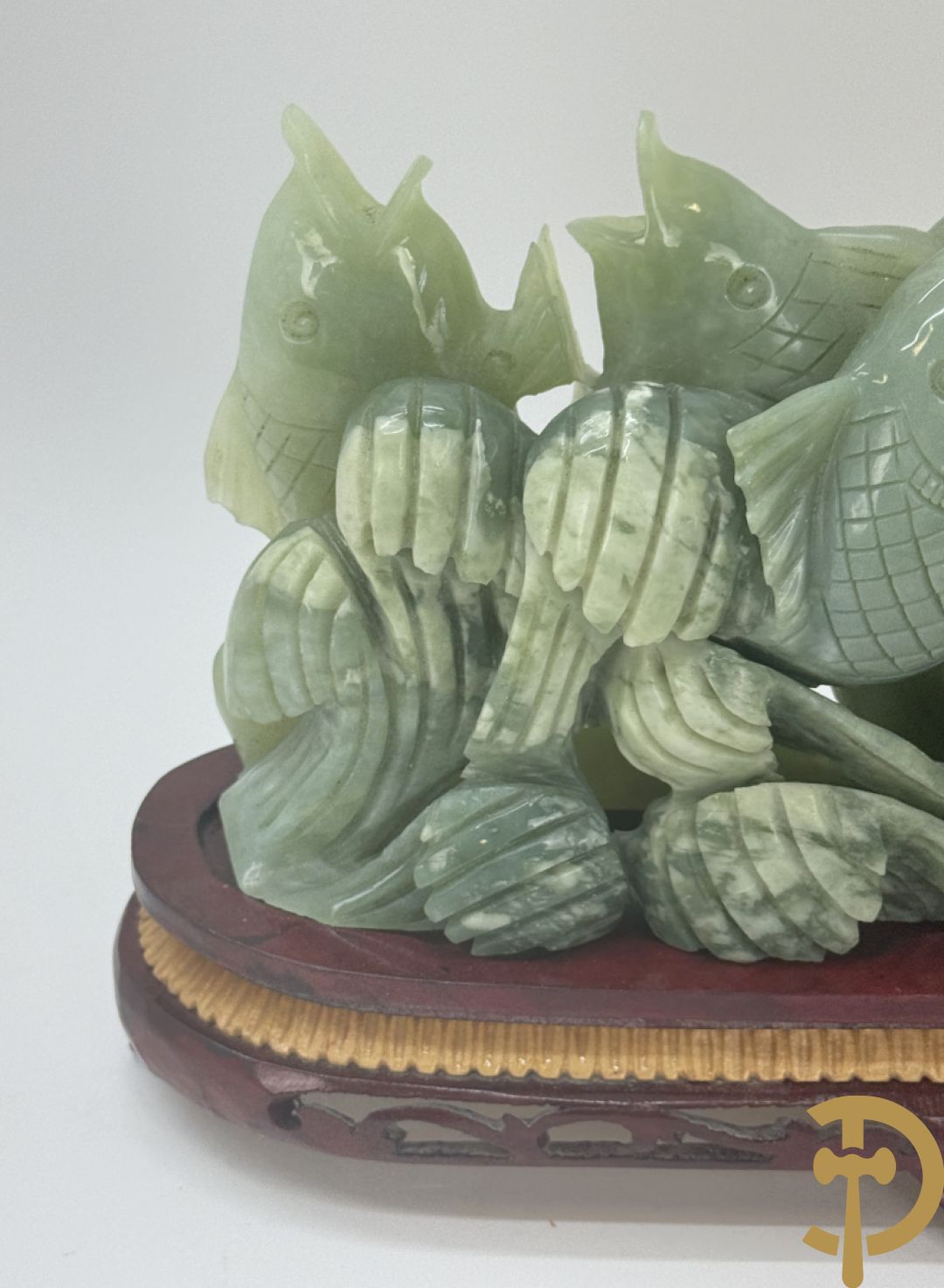 Sculptuur van vissen in jadeiet op houten sokkel