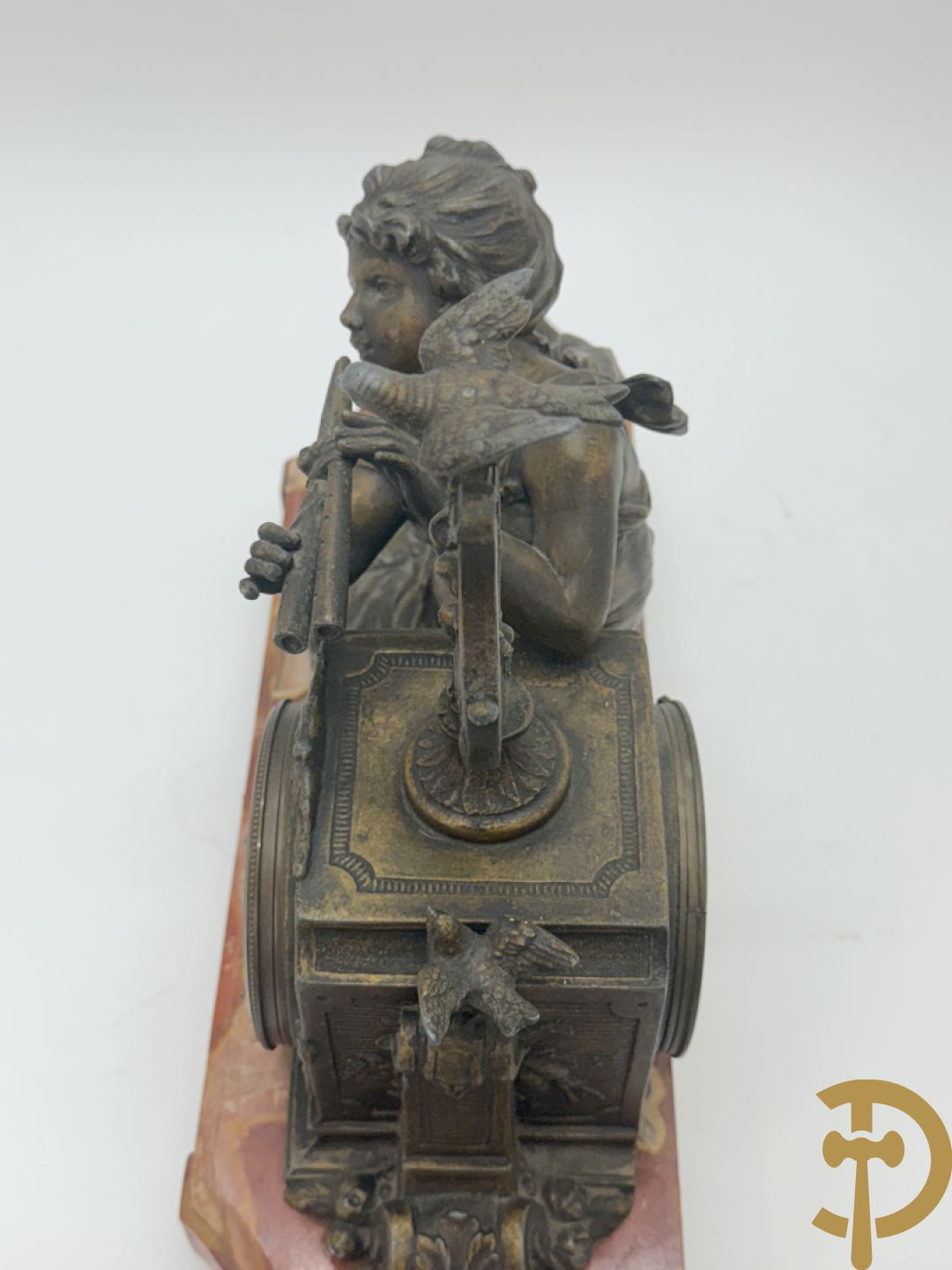 Driedelige garnituur, centraal horloge gedecoreerd met zamak beeld van fluitspelende cupido, geflankeerd door paar cassolettes - alles op marmeren basis