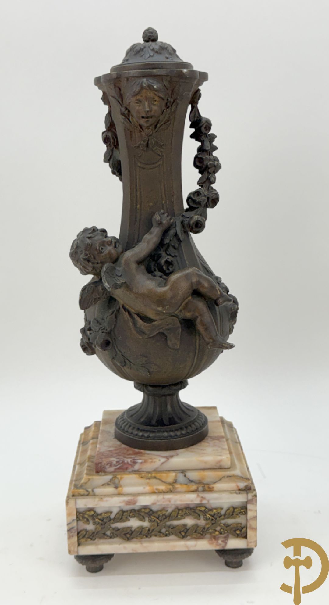Driedelige kunstbronzen garnituur bestaande uit klok met liggende dame met amfoor op marmeren basis, geflankeerd door paar cassolettes met cupido