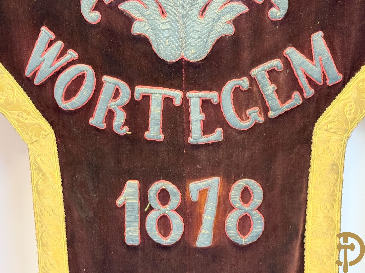 Processiebannier met bordeaux vaandel bezet met goudbrocaat van accanthusranken, Wortegem 1878, centraal handbeschilderd medaillon met voorstelling van Franciscus Xaverius - gehouden door verguld houtgesculpteerd ornament