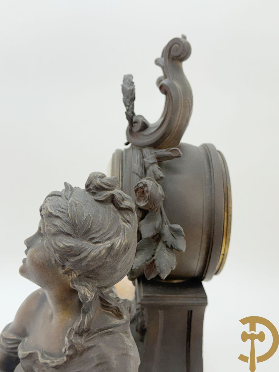 Driedelige kunstbronzen garnituur bestaande uit klok met liggende dame met amfoor op marmeren basis, geflankeerd door paar cassolettes met cupido