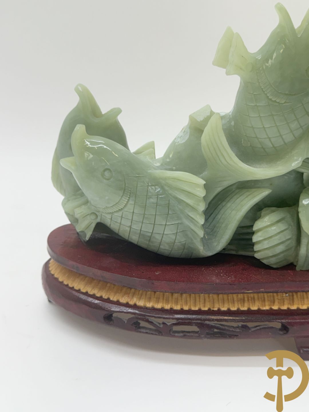 Sculptuur van vissen in jadeiet op houten sokkel
