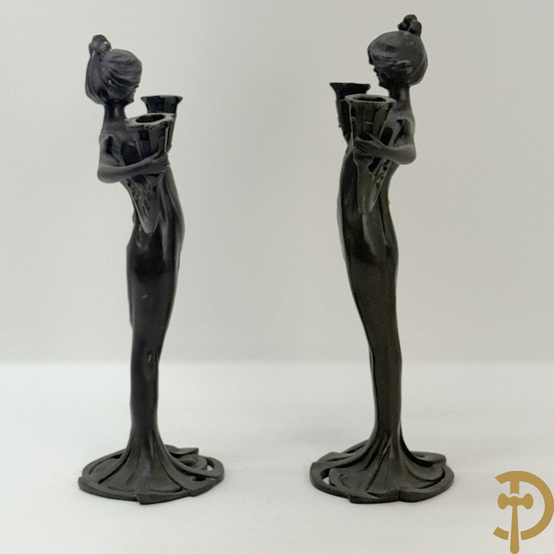 Paar bronzen beelden in de vorm van dames, houdende twee kandelaars