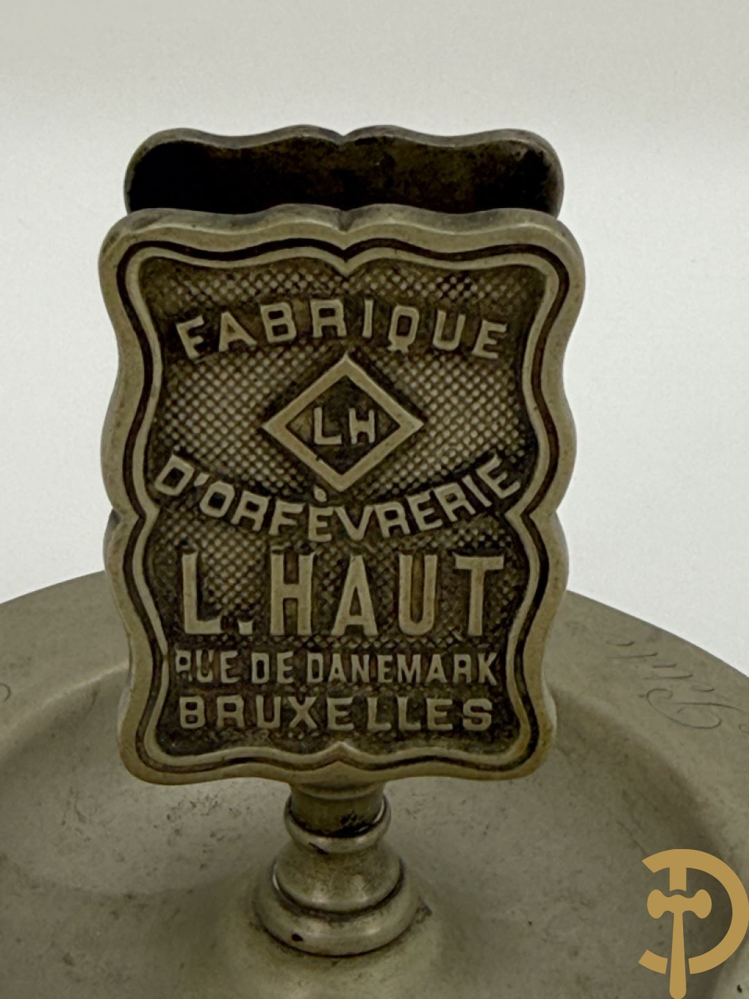 Vier luciferhouders in verzilverd metalen met reclame opschriften van Wiskeman (2 x) , Orfeverie Van Den Torren en Orfeverie L. Haut