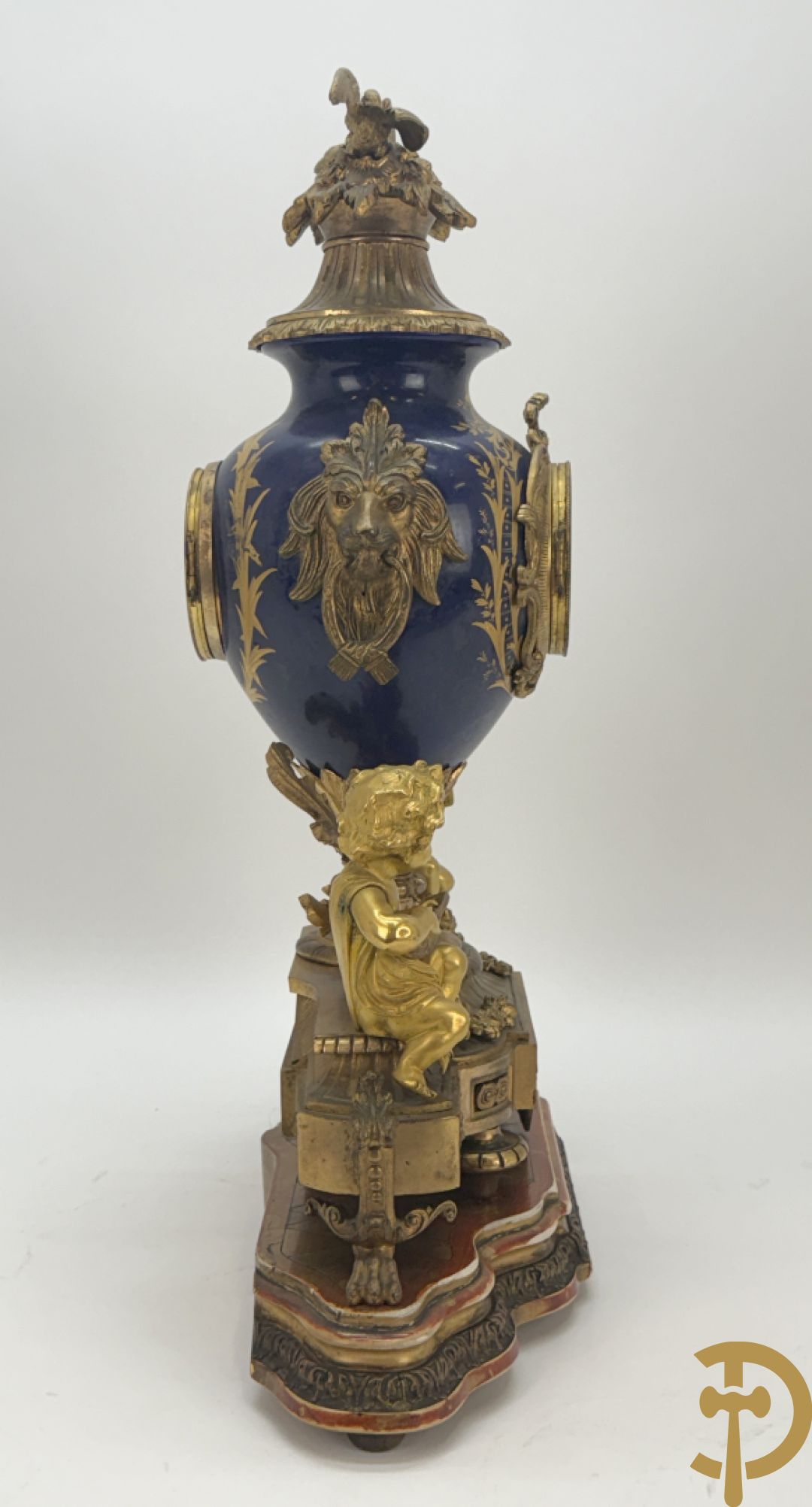 Driedelige vergulde bronzen garnituur bestaande uit pendule met blauw porseleinen coupe geflankeerd door 2 cupido