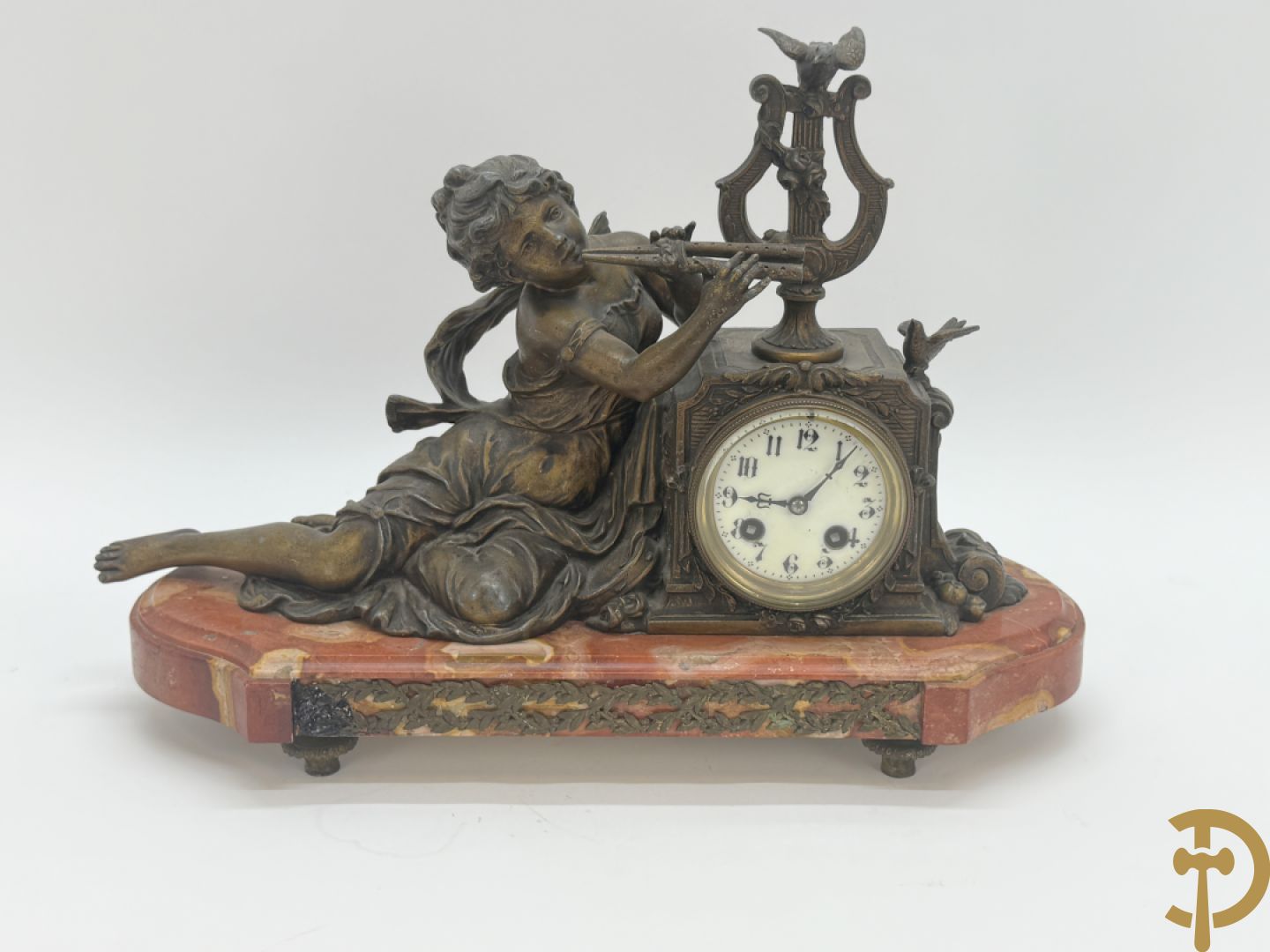 Driedelige garnituur, centraal horloge gedecoreerd met zamak beeld van fluitspelende cupido, geflankeerd door paar cassolettes - alles op marmeren basis