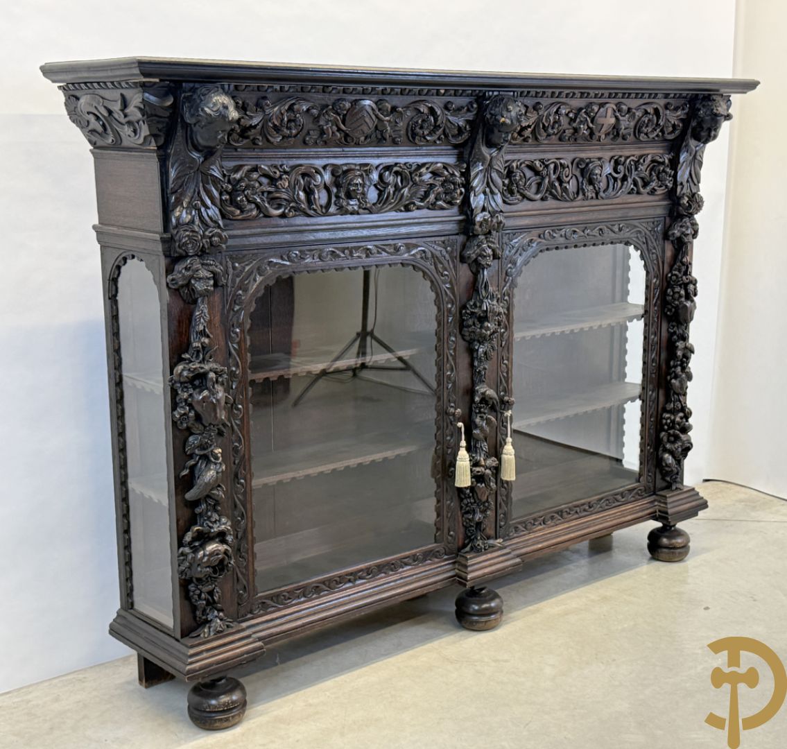 Tweedeursvitrine met Neo Renaissance sculptuur, bovenaan mlet cupidohoofden, bloemen en accanthusranken
