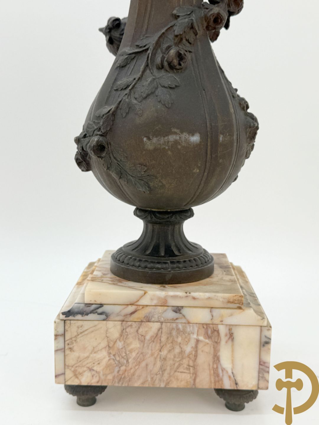 Driedelige kunstbronzen garnituur bestaande uit klok met liggende dame met amfoor op marmeren basis, geflankeerd door paar cassolettes met cupido