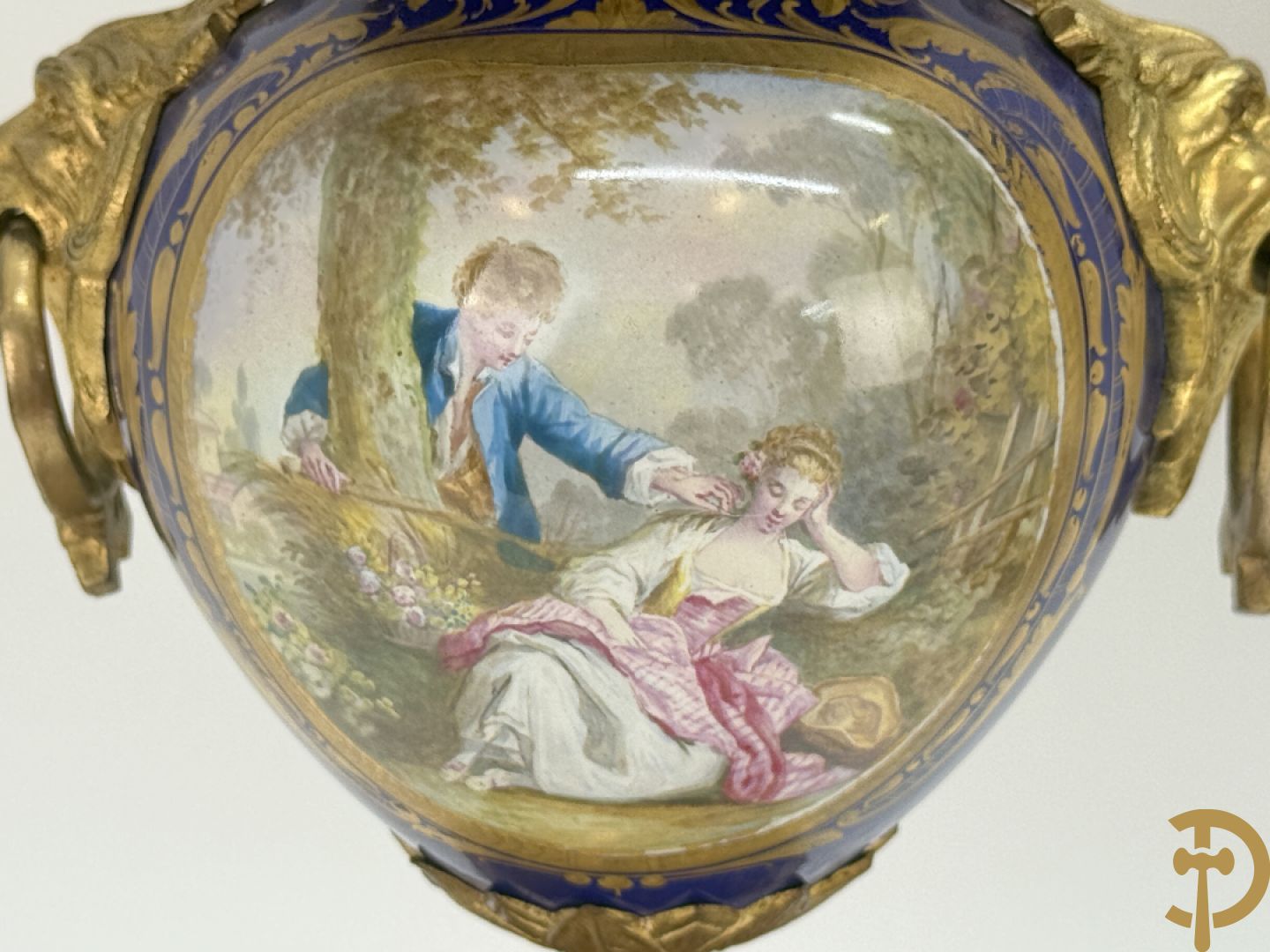 Driedelige vergulde bronzen garnituur bestaande uit pendule met blauw porseleinen coupe geflankeerd door 2 cupido