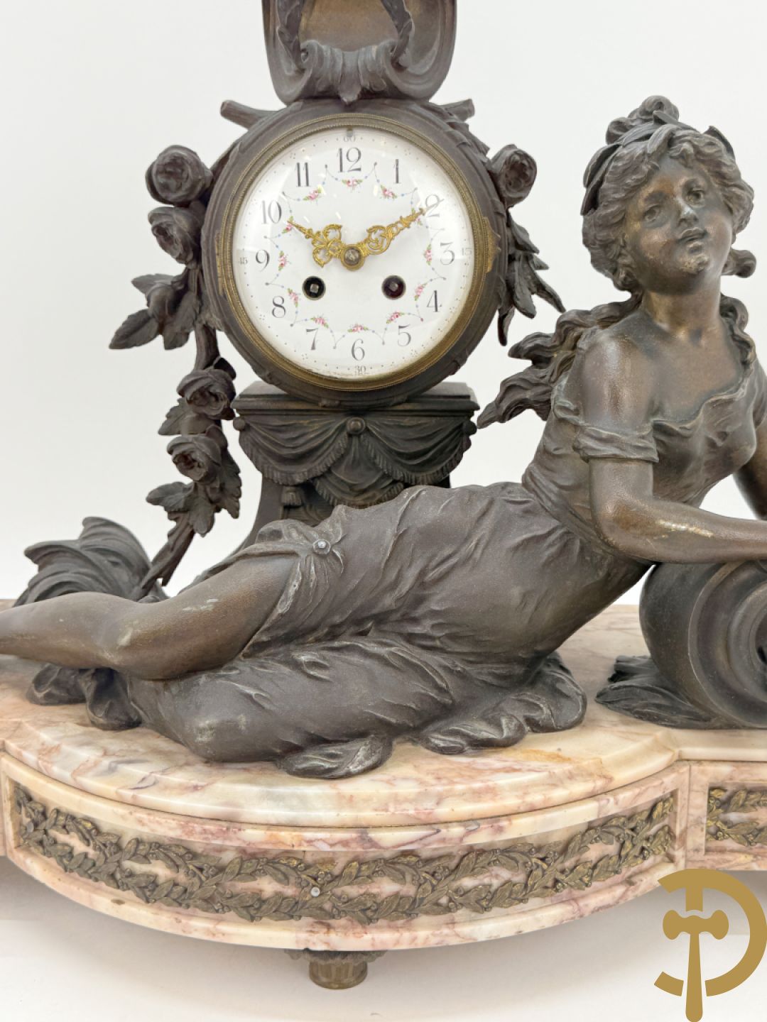 Driedelige kunstbronzen garnituur bestaande uit klok met liggende dame met amfoor op marmeren basis, geflankeerd door paar cassolettes met cupido