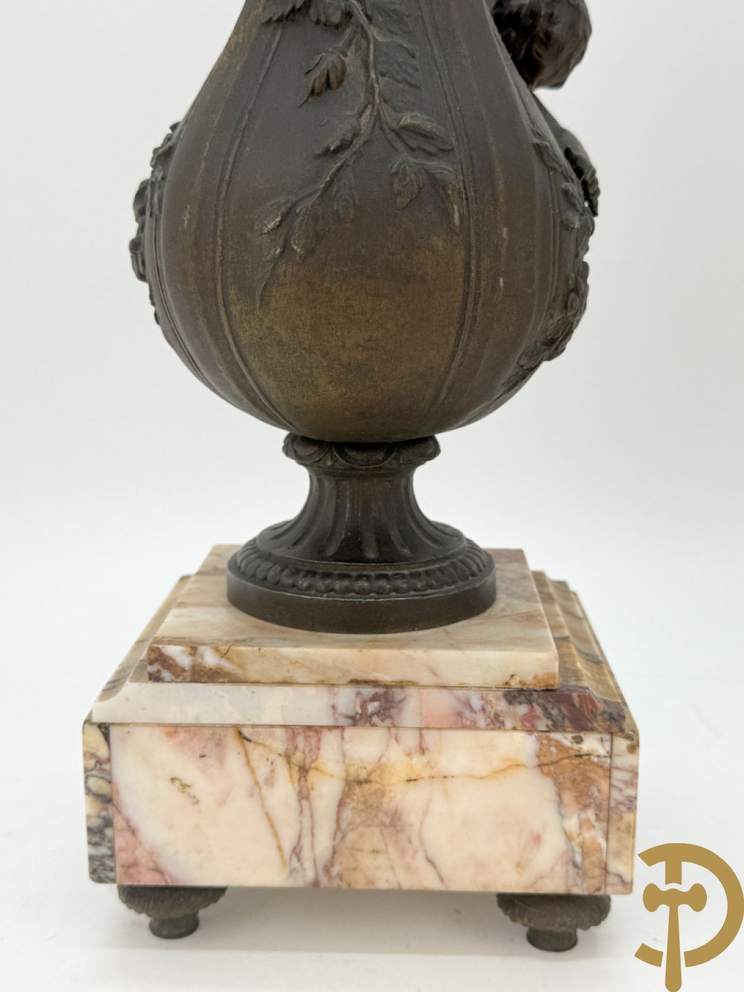 Driedelige kunstbronzen garnituur bestaande uit klok met liggende dame met amfoor op marmeren basis, geflankeerd door paar cassolettes met cupido