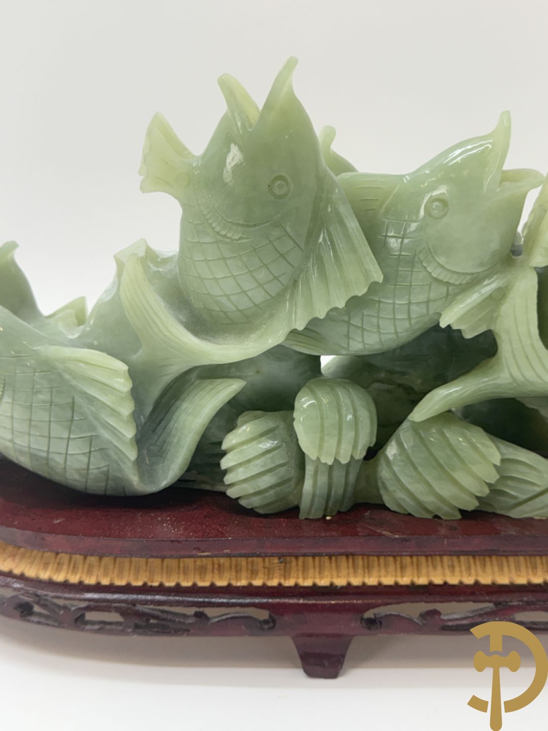 Sculptuur van vissen in jadeiet op houten sokkel