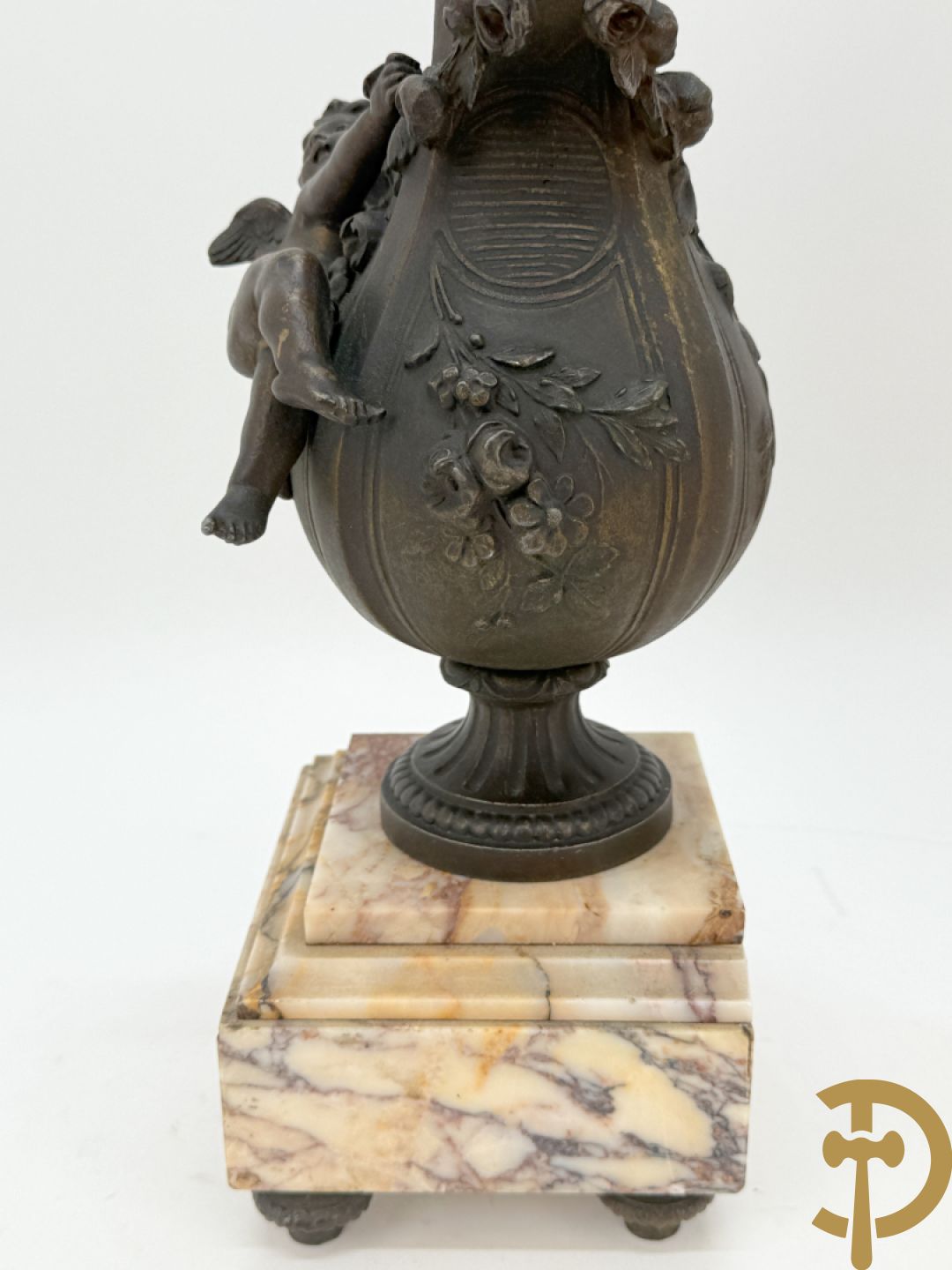 Driedelige kunstbronzen garnituur bestaande uit klok met liggende dame met amfoor op marmeren basis, geflankeerd door paar cassolettes met cupido