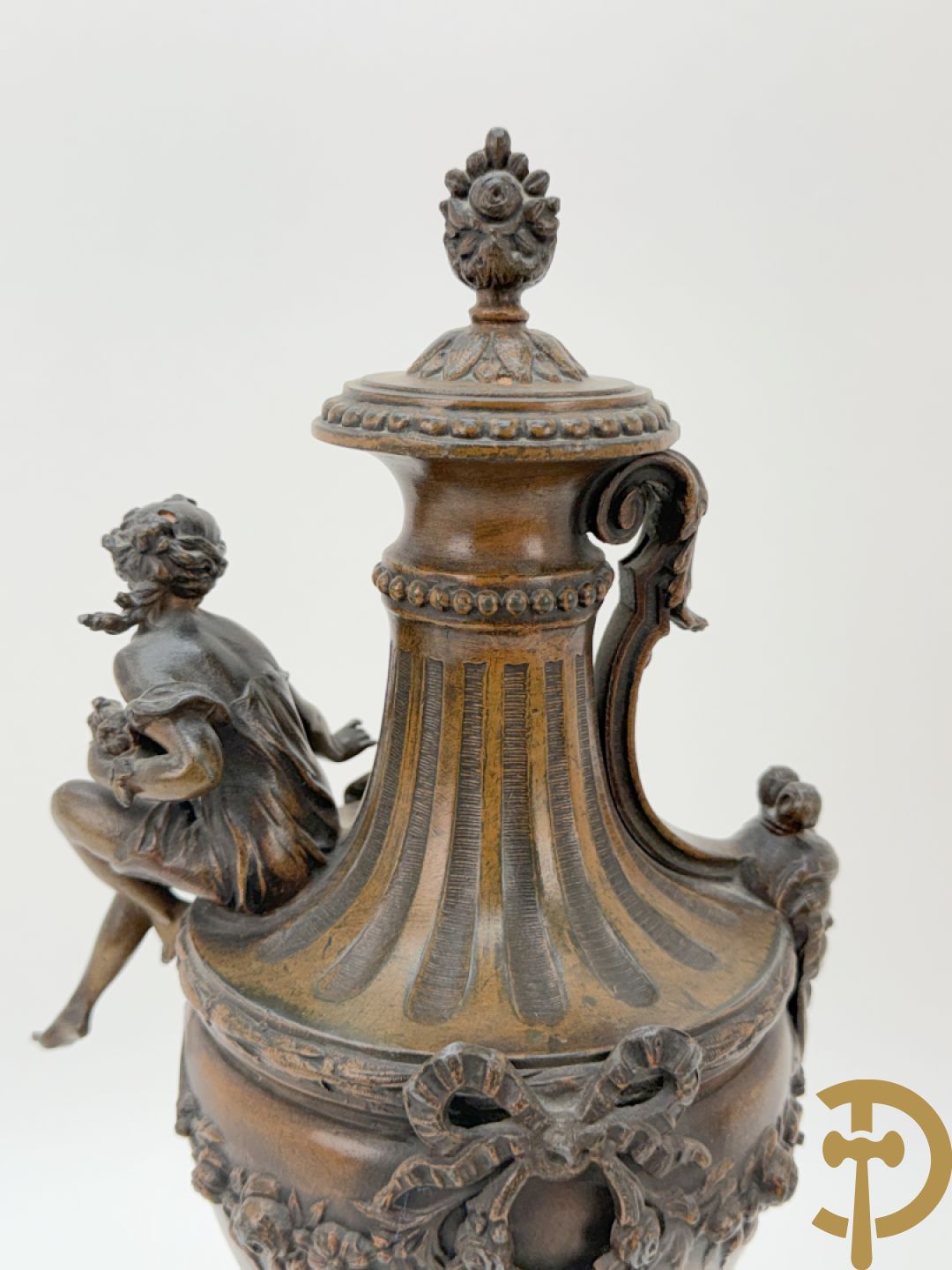 Driedelige schouwgarnituur met centrale pendule met liggende dame en cupido, geflankeerd door paar cassolettes met elegante dame