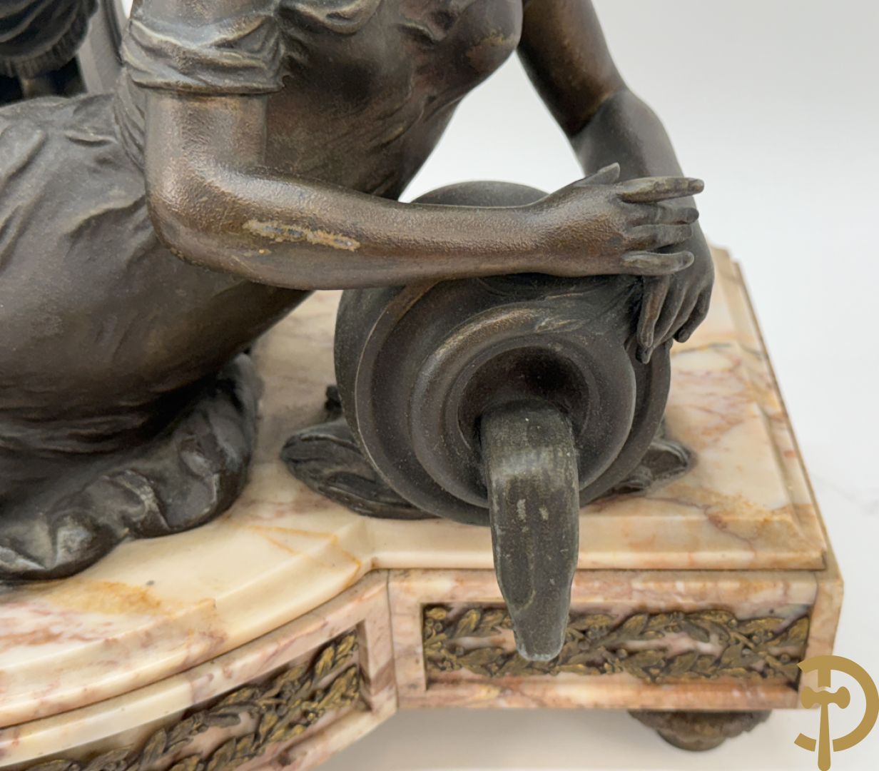 Driedelige kunstbronzen garnituur bestaande uit klok met liggende dame met amfoor op marmeren basis, geflankeerd door paar cassolettes met cupido