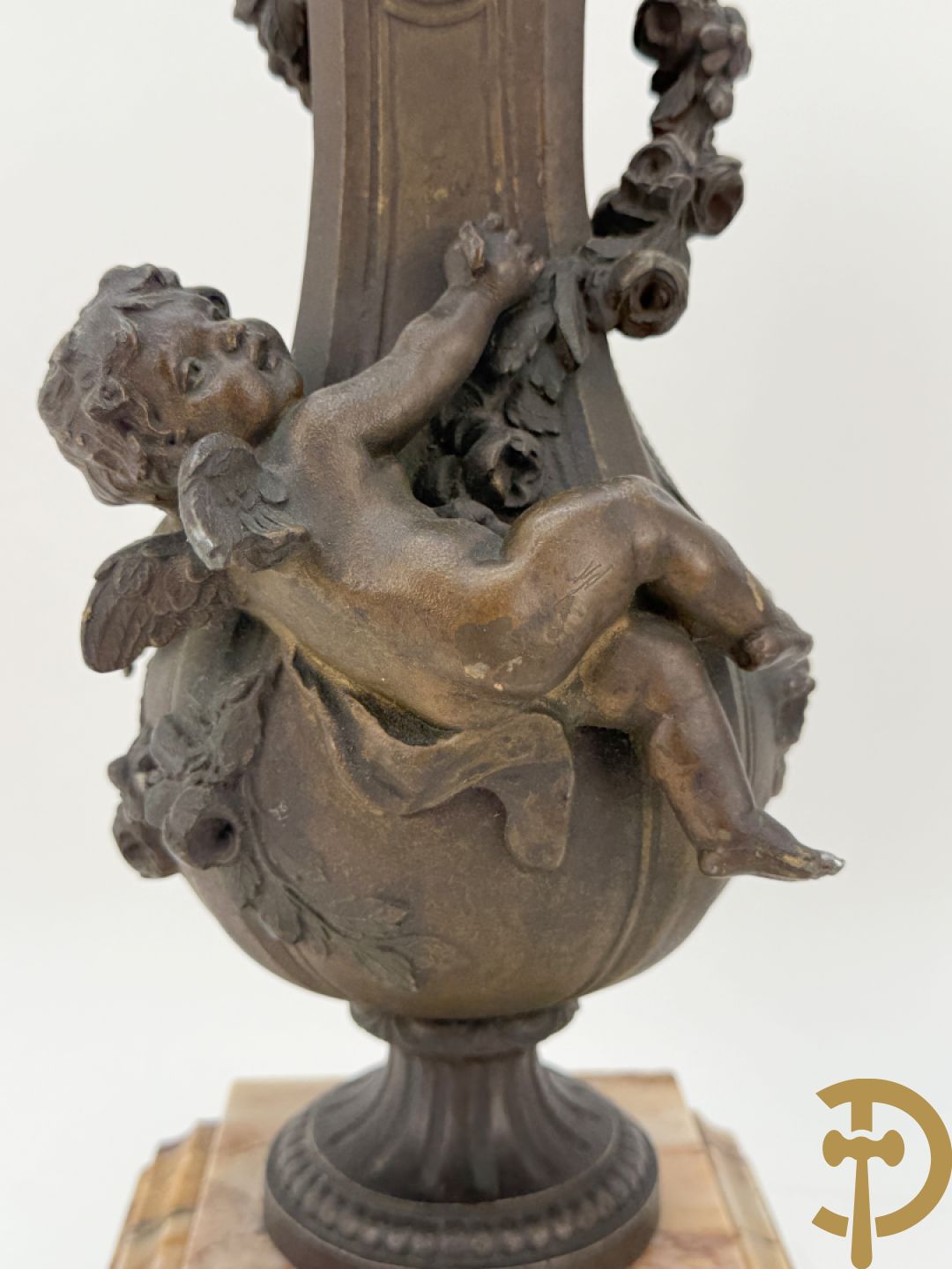 Driedelige kunstbronzen garnituur bestaande uit klok met liggende dame met amfoor op marmeren basis, geflankeerd door paar cassolettes met cupido