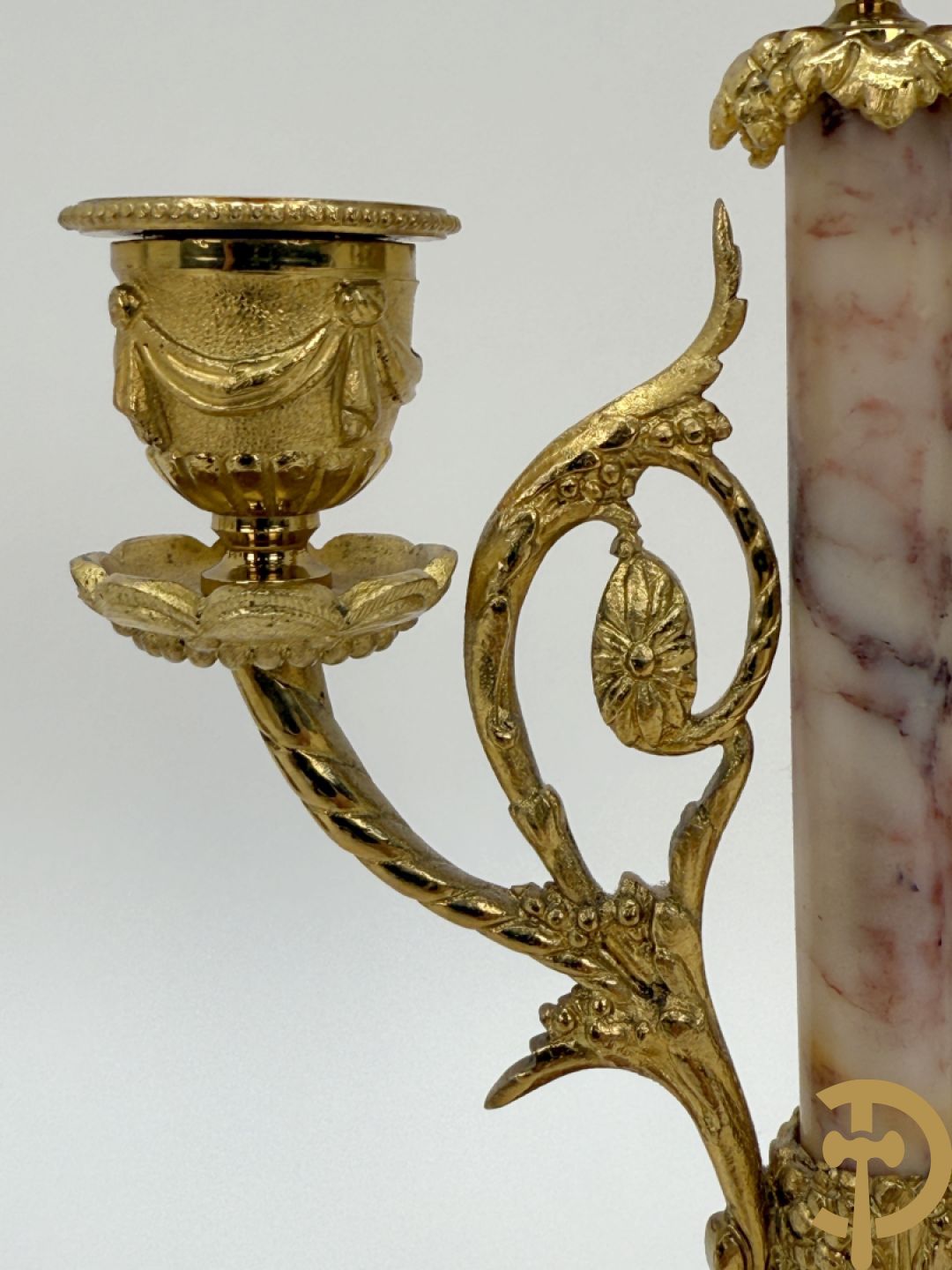 Driedelige marmeren garnituur bestaande uit vierzuilenpendule geflankeerd door paar twee armige kandelaars met brons bezet, Dainage à Calais getekend