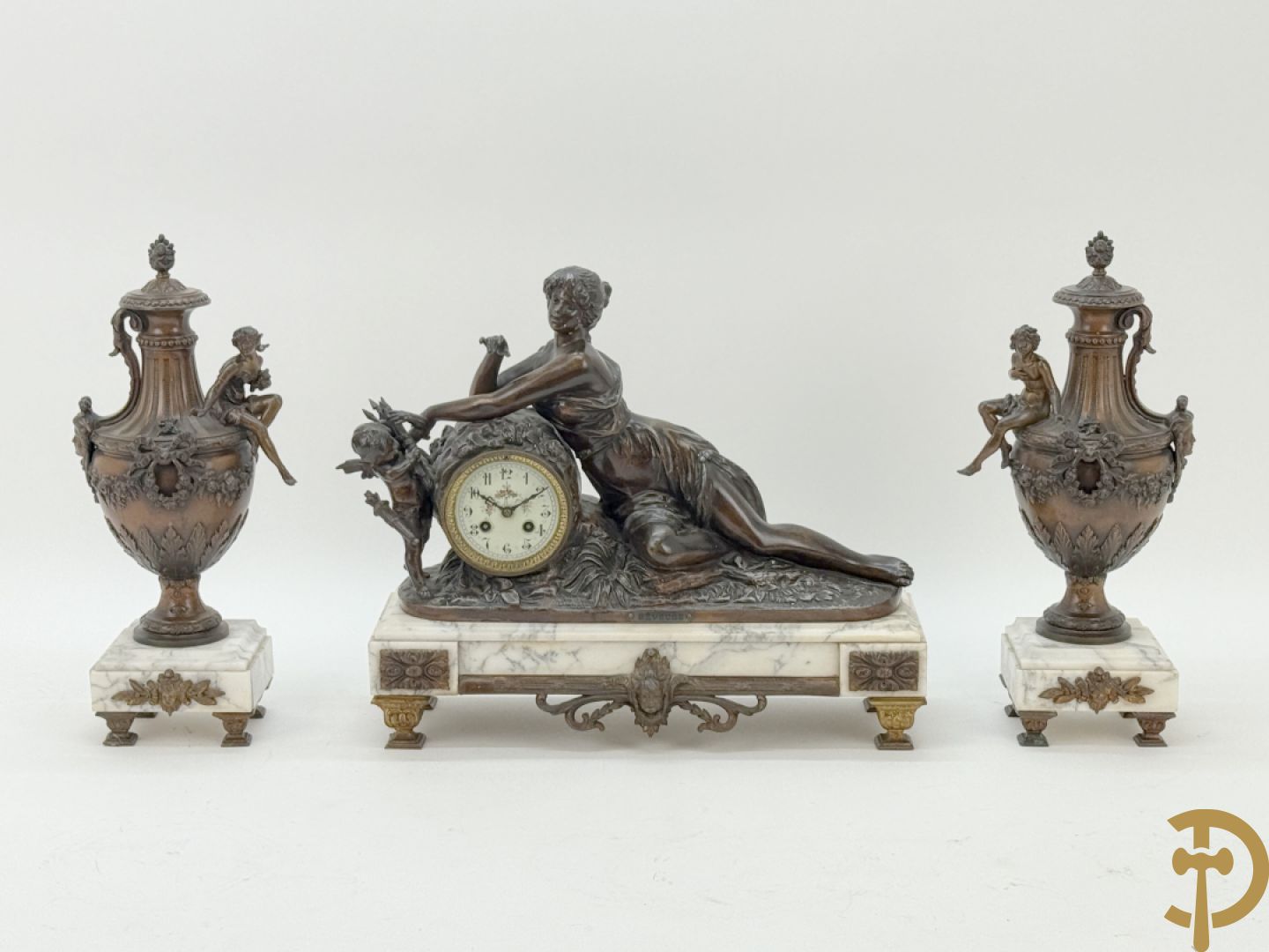 Driedelige schouwgarnituur met centrale pendule met liggende dame en cupido, geflankeerd door paar cassolettes met elegante dame