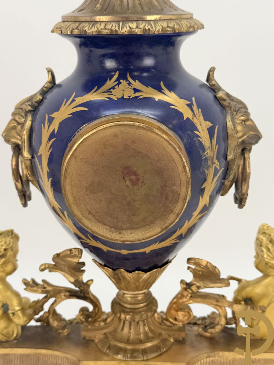 Driedelige vergulde bronzen garnituur bestaande uit pendule met blauw porseleinen coupe geflankeerd door 2 cupido