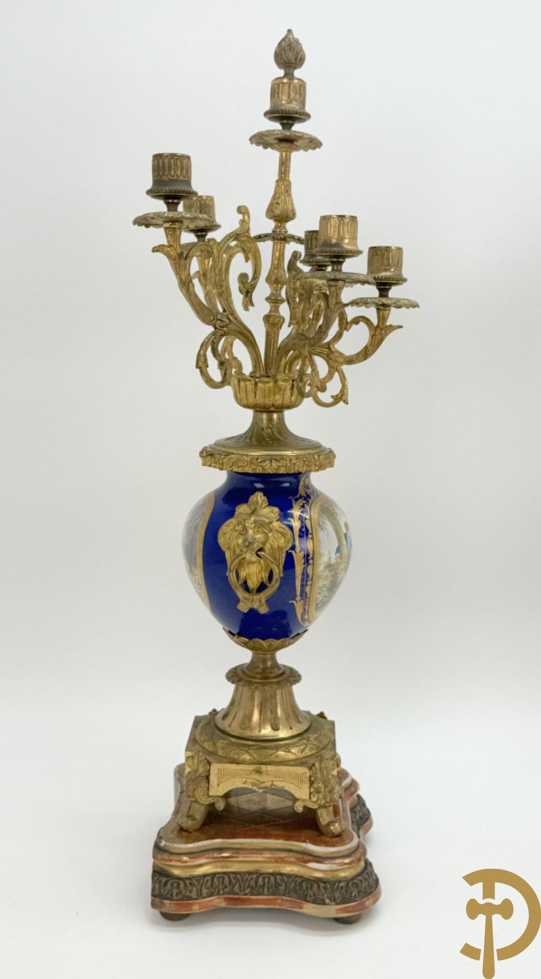 Driedelige vergulde bronzen garnituur bestaande uit pendule met blauw porseleinen coupe geflankeerd door 2 cupido