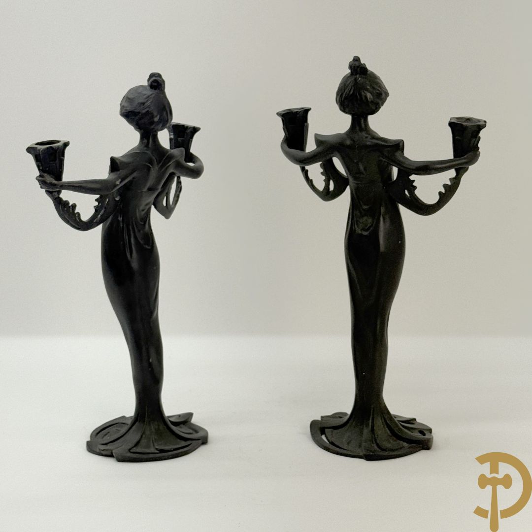 Paar bronzen beelden in de vorm van dames, houdende twee kandelaars