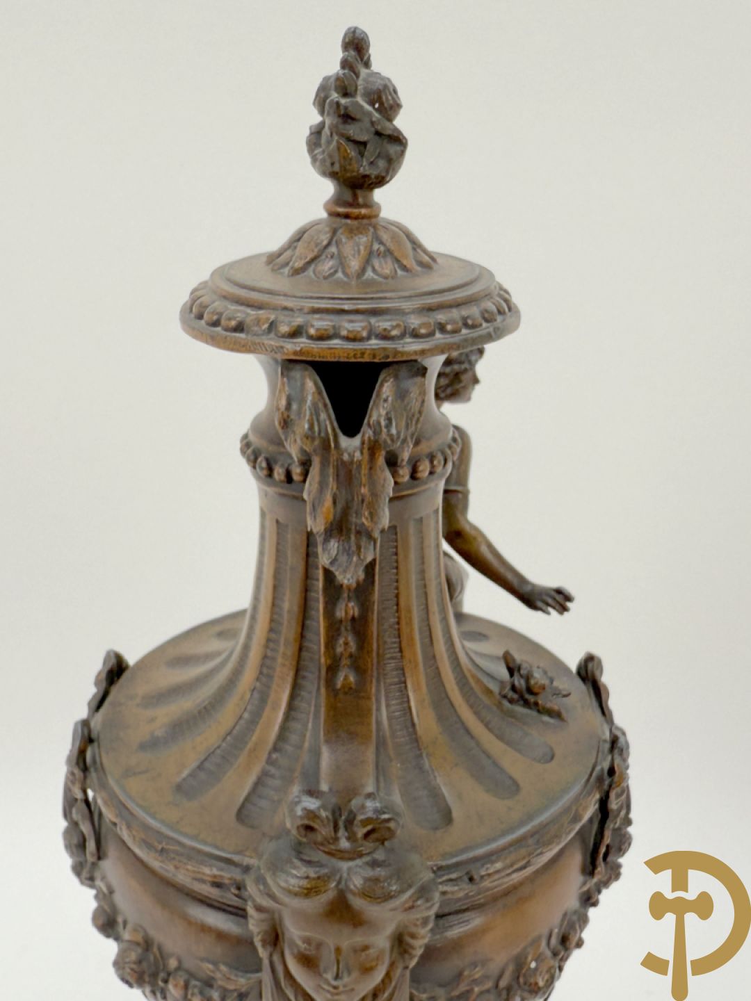 Driedelige schouwgarnituur met centrale pendule met liggende dame en cupido, geflankeerd door paar cassolettes met elegante dame