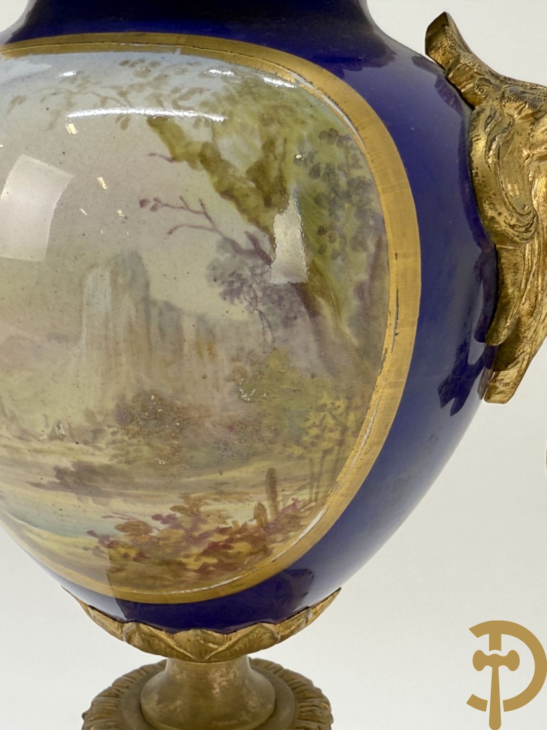Driedelige vergulde bronzen garnituur bestaande uit pendule met blauw porseleinen coupe geflankeerd door 2 cupido