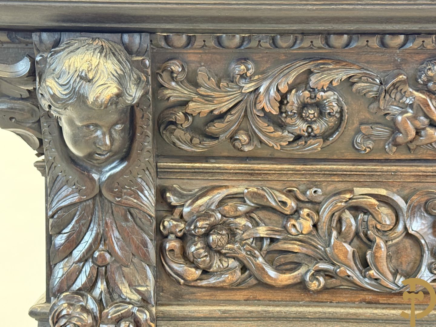 Tweedeursvitrine met Neo Renaissance sculptuur, bovenaan mlet cupidohoofden, bloemen en accanthusranken