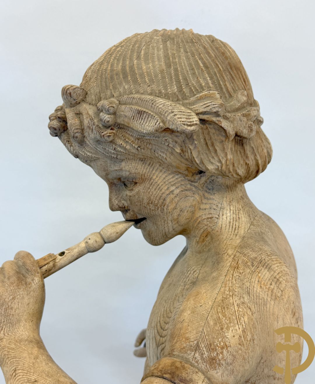 Houtgesculpteerde fluitspelende cupido staande op schelp