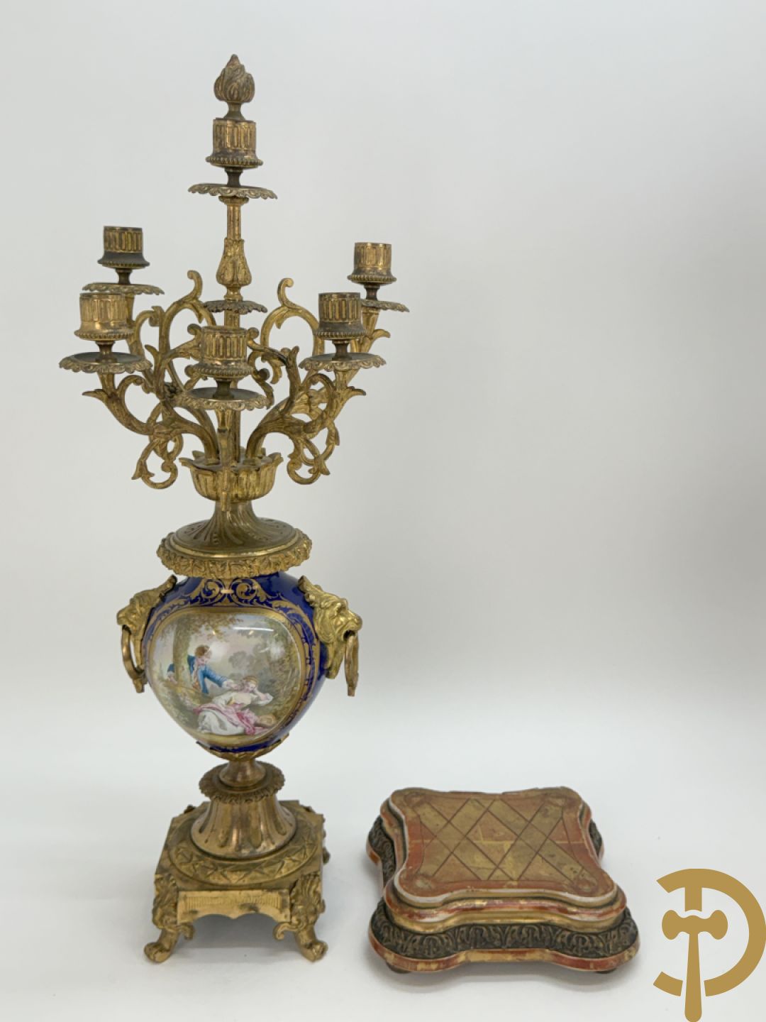 Driedelige vergulde bronzen garnituur bestaande uit pendule met blauw porseleinen coupe geflankeerd door 2 cupido