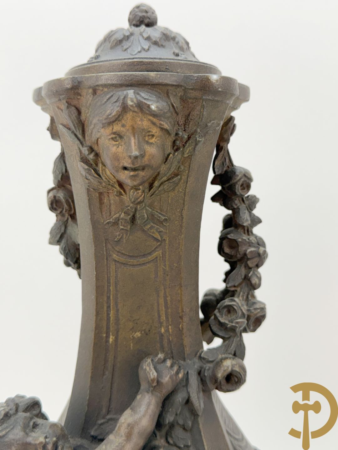 Driedelige kunstbronzen garnituur bestaande uit klok met liggende dame met amfoor op marmeren basis, geflankeerd door paar cassolettes met cupido