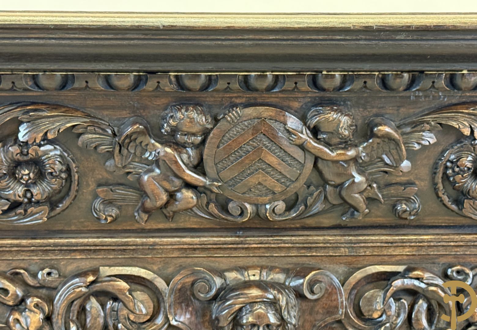 Tweedeursvitrine met Neo Renaissance sculptuur, bovenaan mlet cupidohoofden, bloemen en accanthusranken