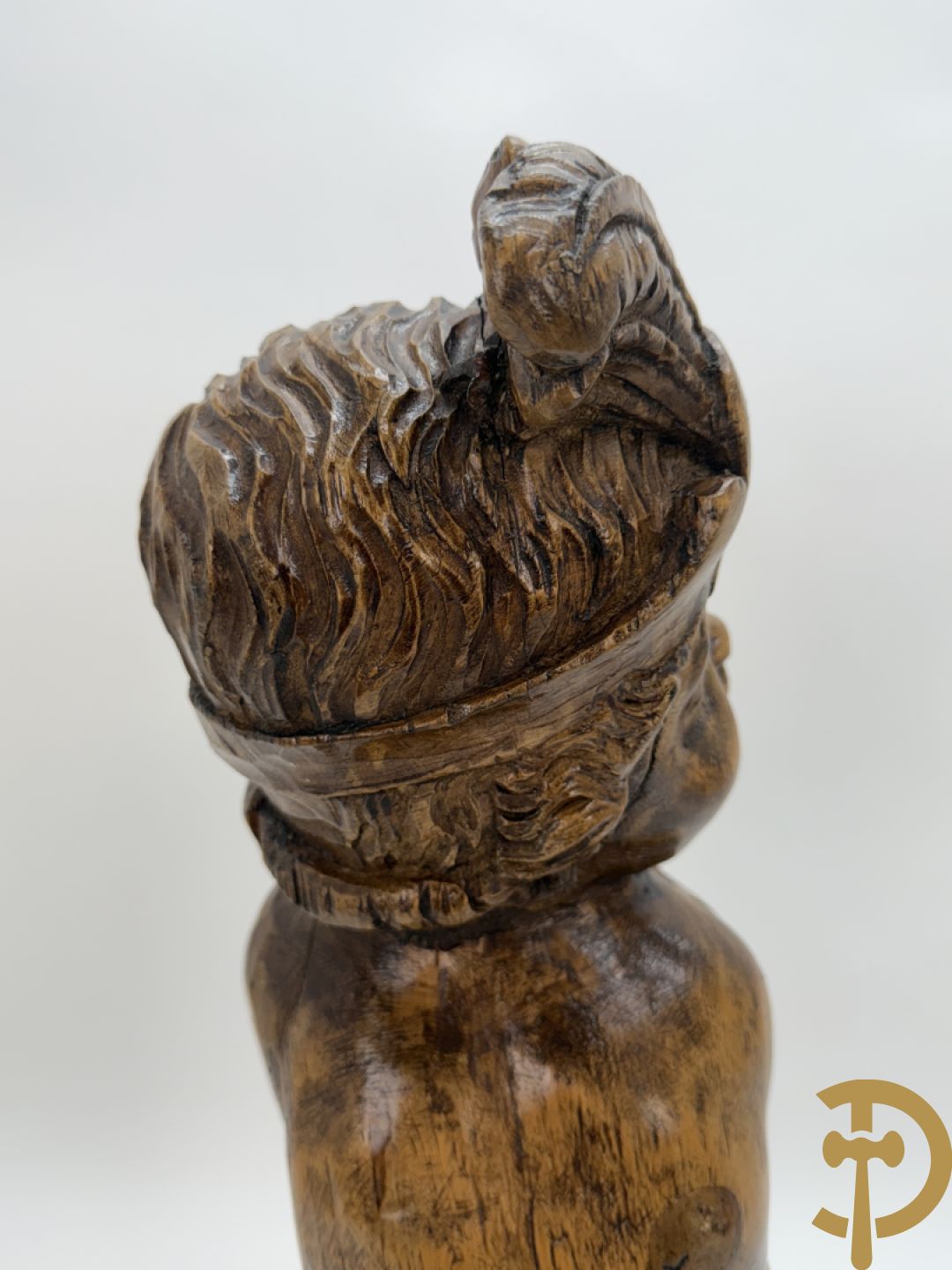 Houtgesculpteerde cupido met gevouwen handen en pluimen