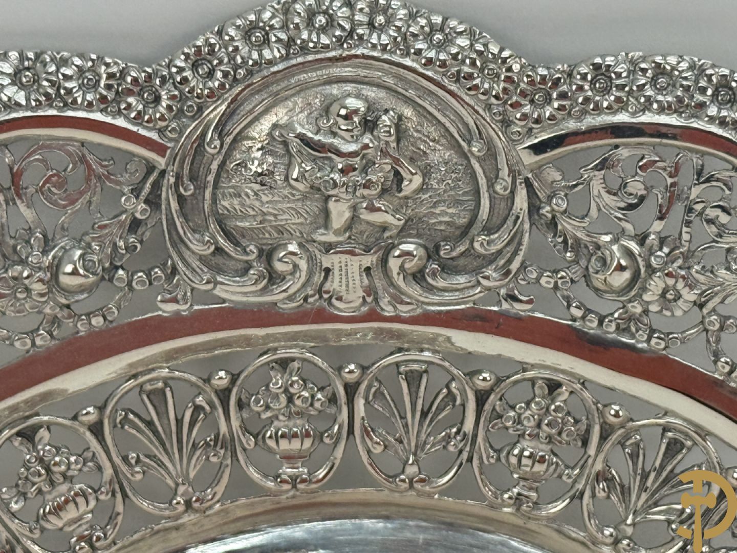 Massief zilveren geajoureerd schaaltje met centraal decor van cupido
