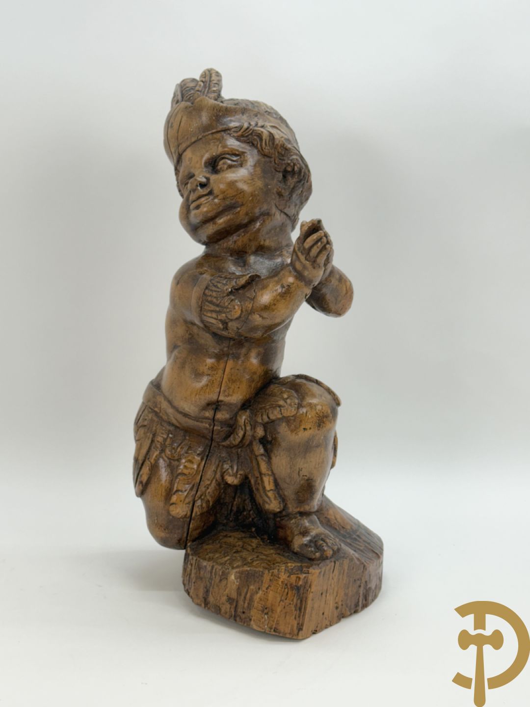 Houtgesculpteerde cupido met gevouwen handen en pluimen