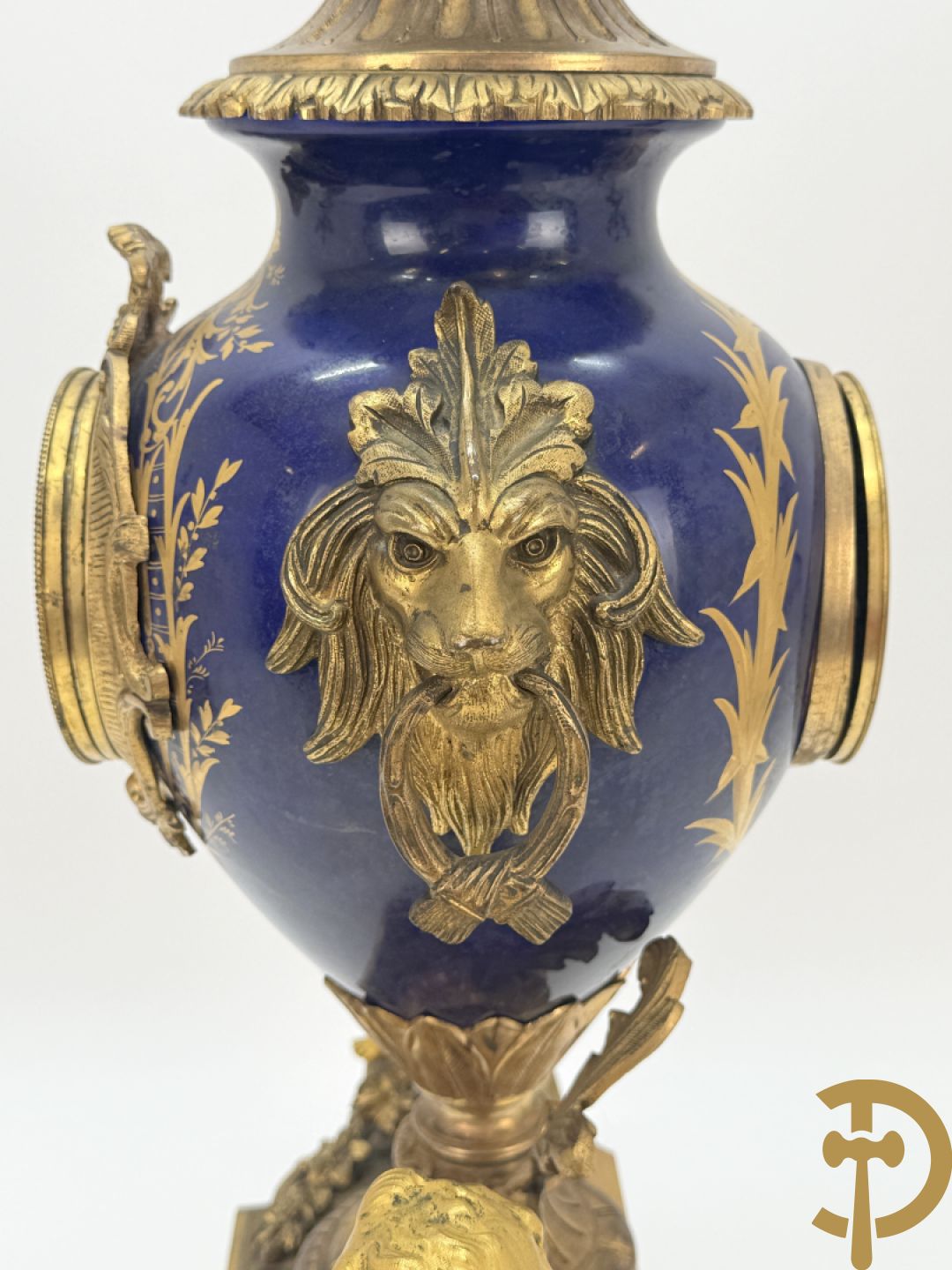 Driedelige vergulde bronzen garnituur bestaande uit pendule met blauw porseleinen coupe geflankeerd door 2 cupido