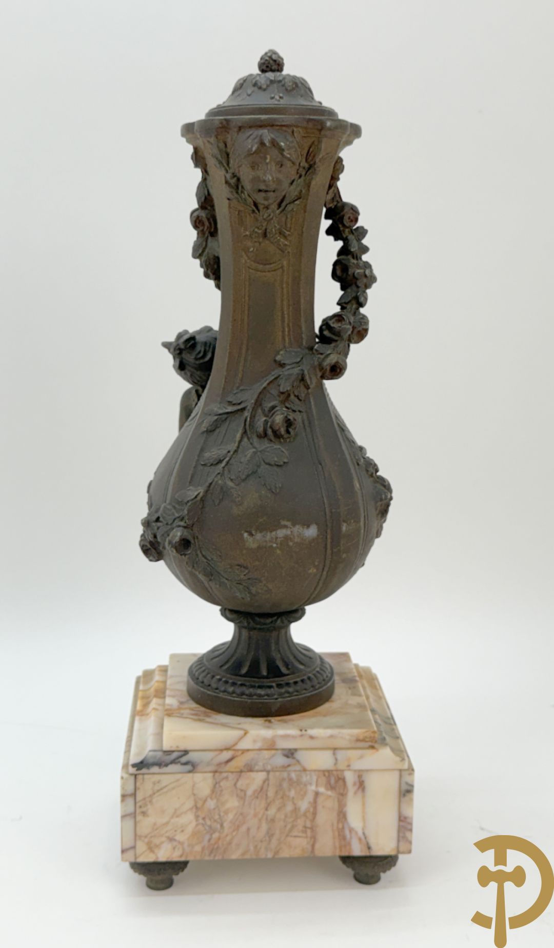 Driedelige kunstbronzen garnituur bestaande uit klok met liggende dame met amfoor op marmeren basis, geflankeerd door paar cassolettes met cupido