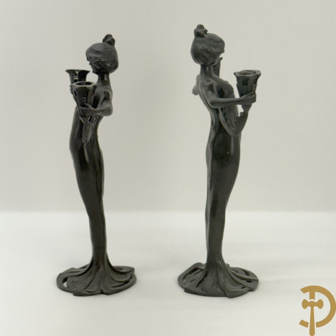 Paar bronzen beelden in de vorm van dames, houdende twee kandelaars