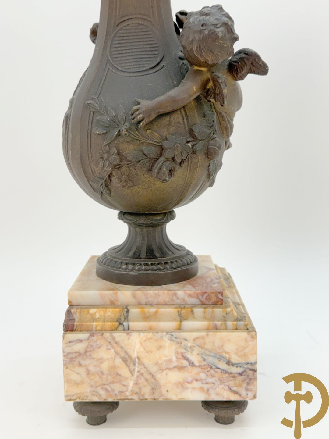 Driedelige kunstbronzen garnituur bestaande uit klok met liggende dame met amfoor op marmeren basis, geflankeerd door paar cassolettes met cupido