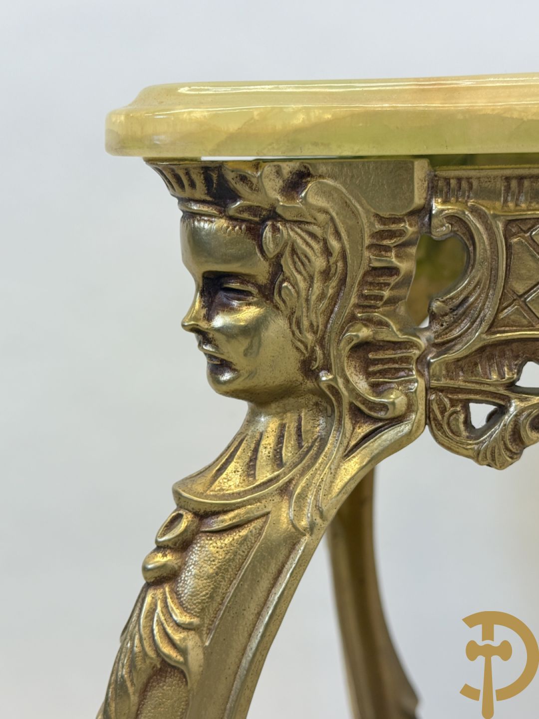 Vergulde metalen sokkel met accanthusranken op voluutvormige poten