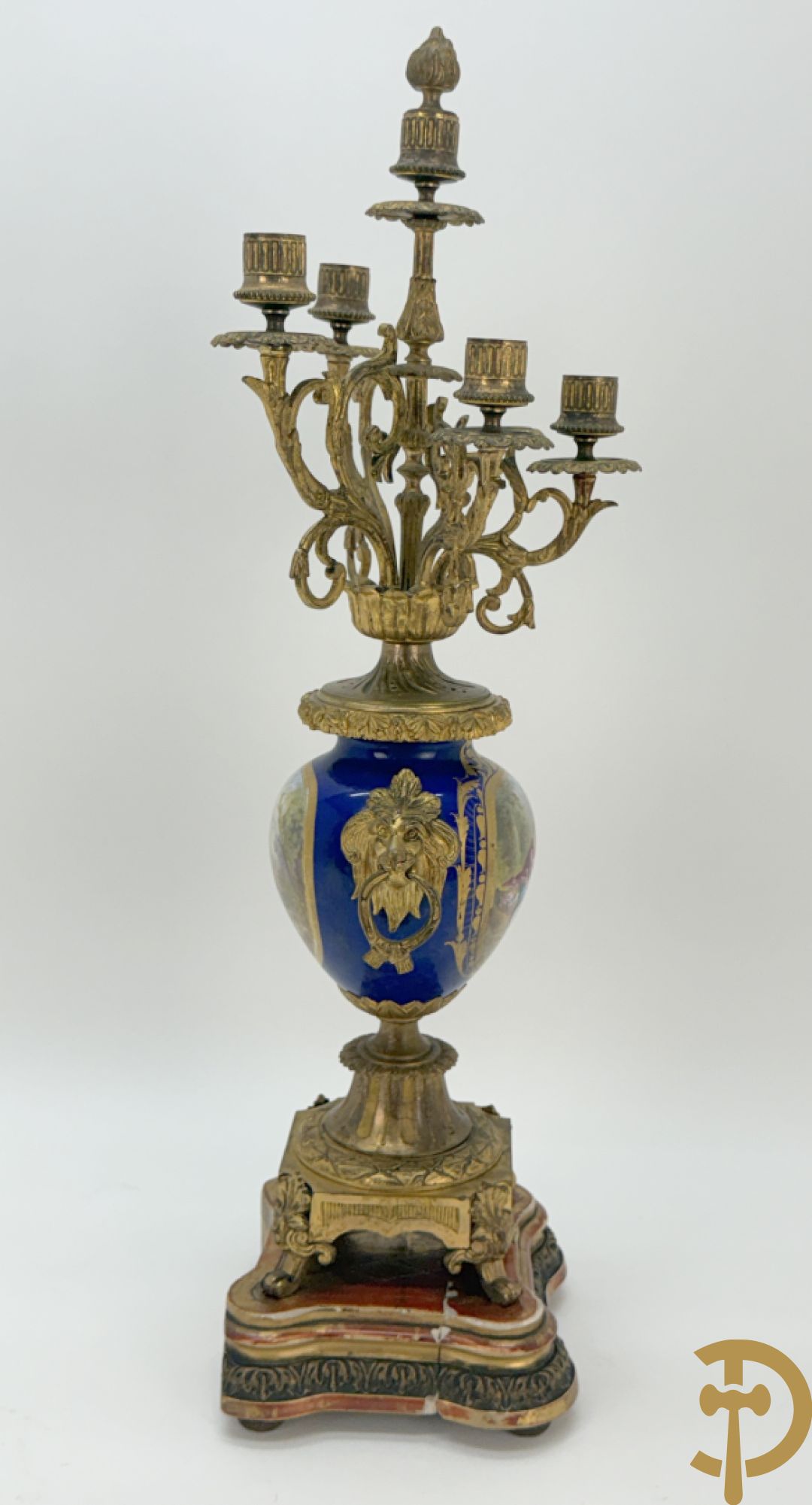 Driedelige vergulde bronzen garnituur bestaande uit pendule met blauw porseleinen coupe geflankeerd door 2 cupido