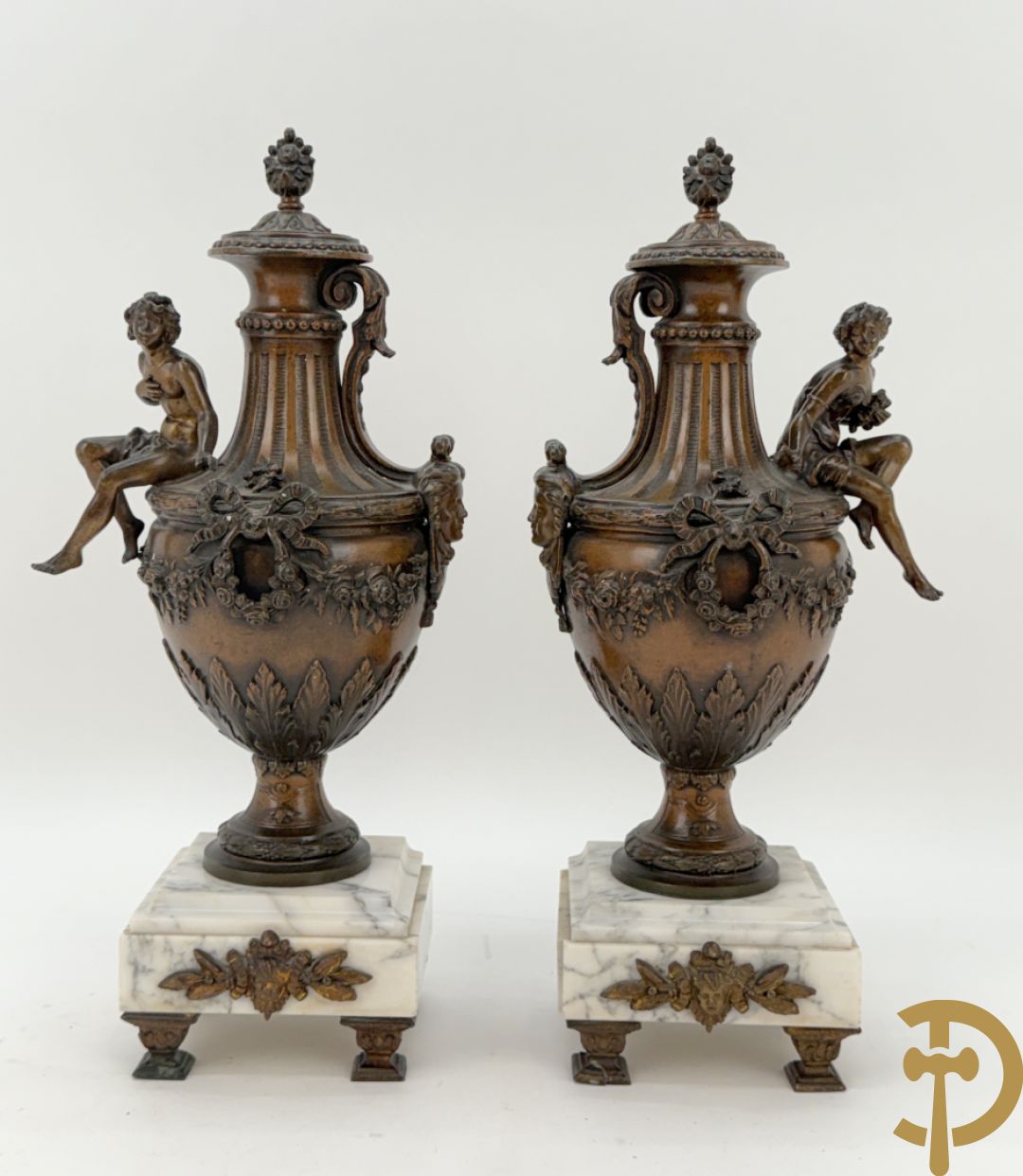 Driedelige schouwgarnituur met centrale pendule met liggende dame en cupido, geflankeerd door paar cassolettes met elegante dame