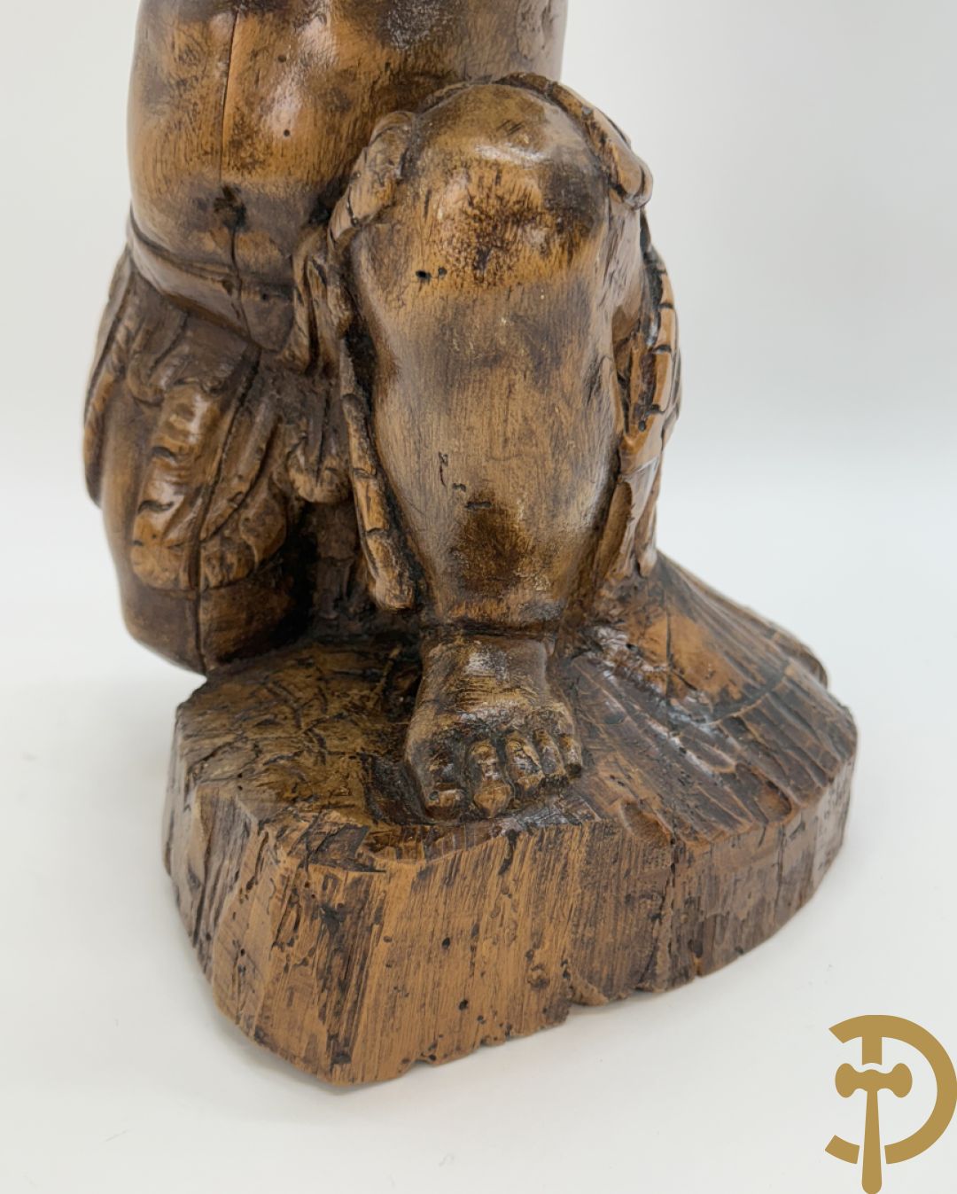 Houtgesculpteerde cupido met gevouwen handen en pluimen