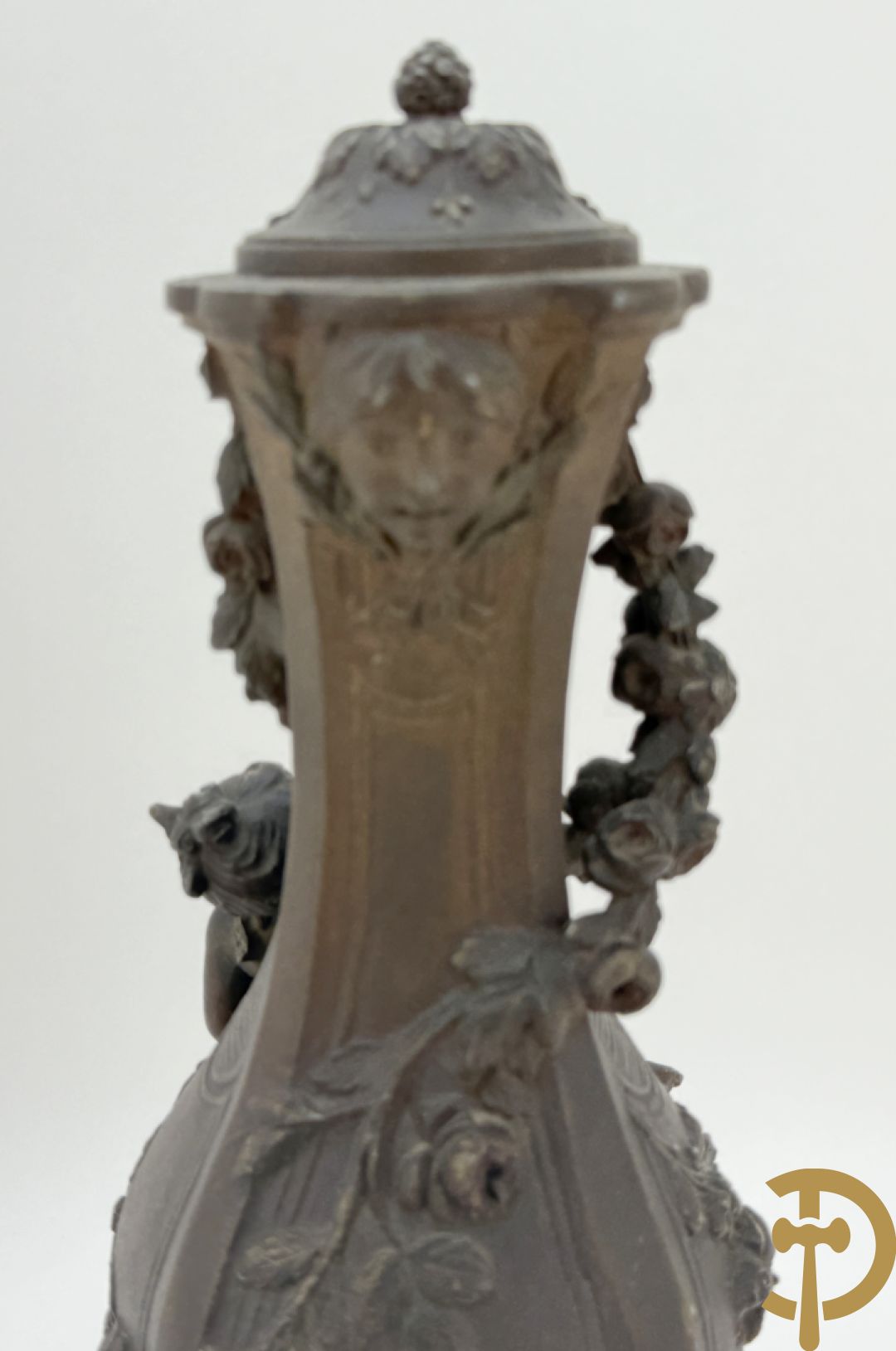 Driedelige kunstbronzen garnituur bestaande uit klok met liggende dame met amfoor op marmeren basis, geflankeerd door paar cassolettes met cupido