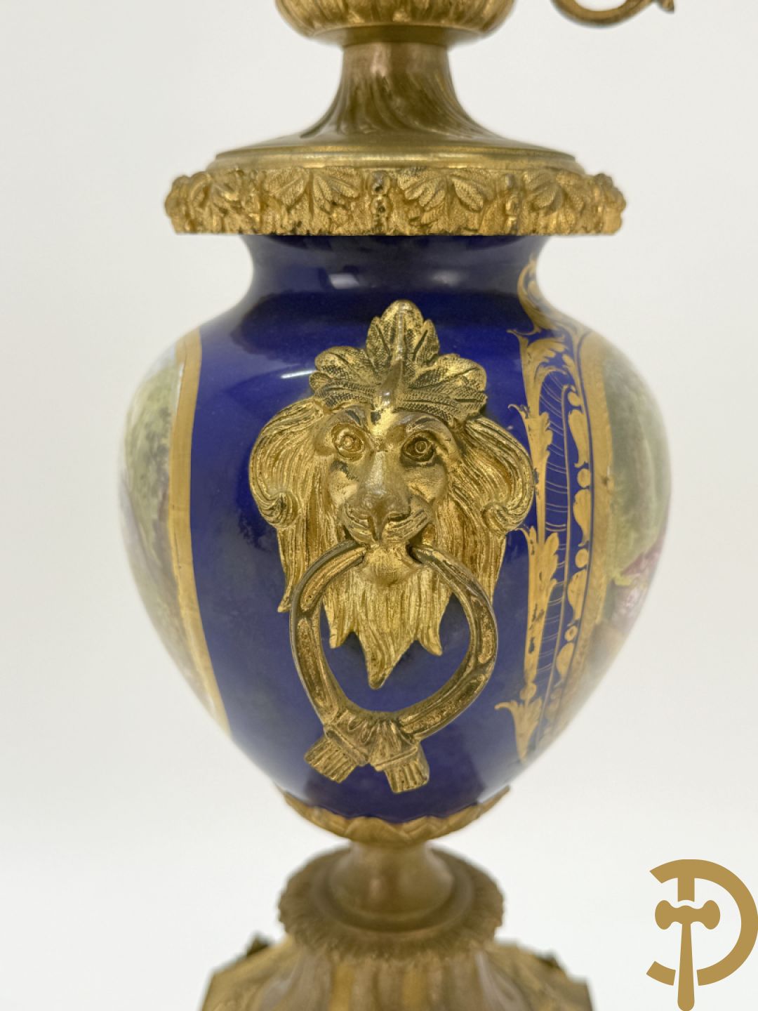 Driedelige vergulde bronzen garnituur bestaande uit pendule met blauw porseleinen coupe geflankeerd door 2 cupido
