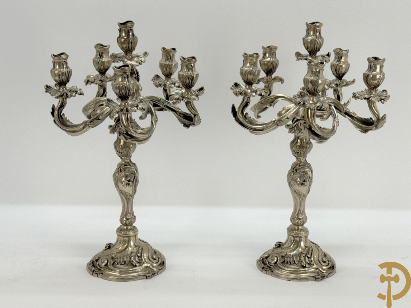Paar massief zilveren getorste zesarmige kandelaars met Louis XV motieven, met import stempel 